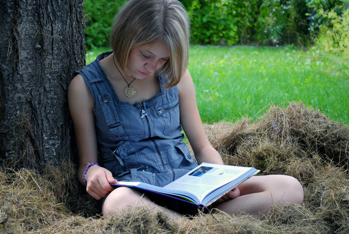 树下看书的女孩摄影图