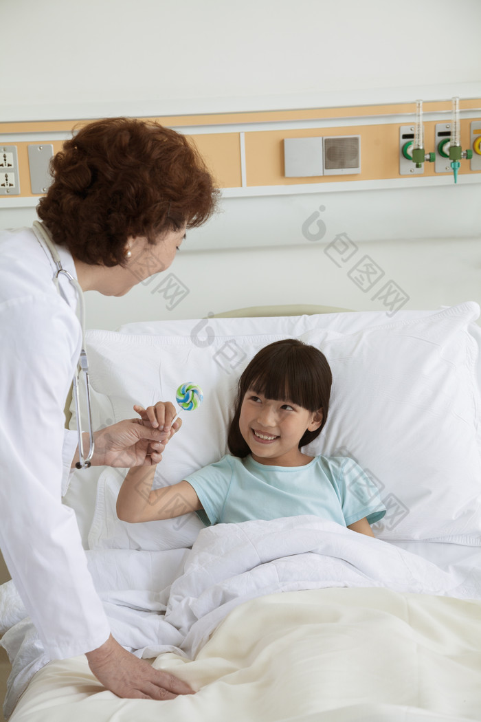医生拿给病床上的女孩棒棒糖