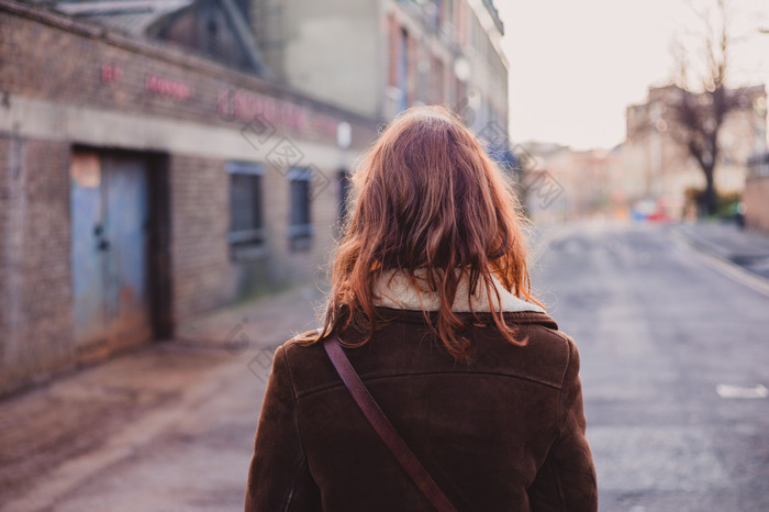 荒凉的街道上走路的女人摄影图