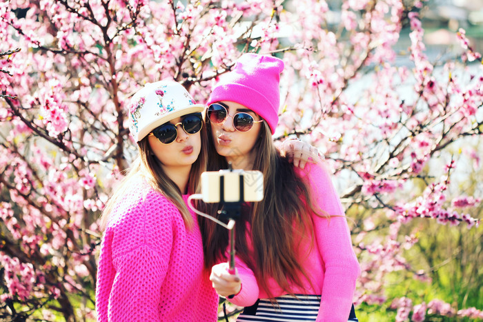 两个女孩桃花树前自拍图片