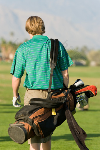 男人背着高尔夫球杆的背影
