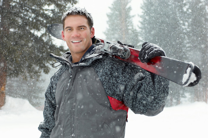 冬天扛着滑雪板的男人