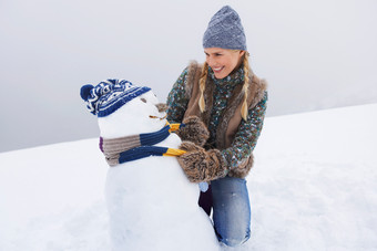 灰色调堆雪人的女孩摄影图