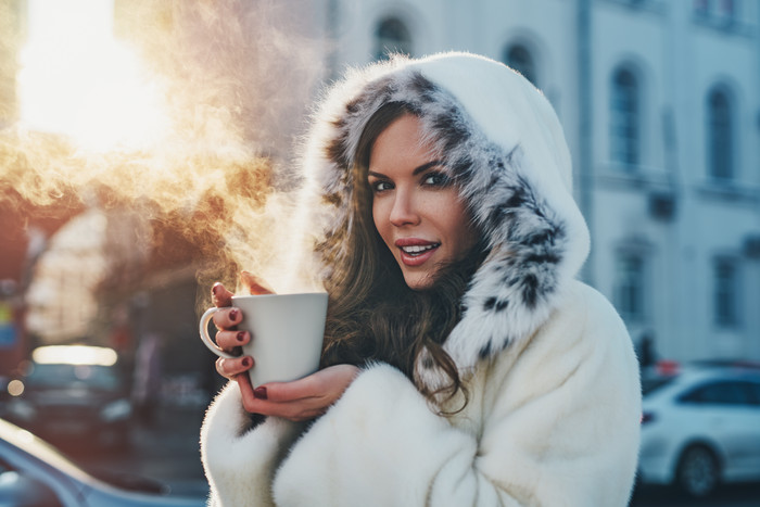 冬季女人端着热咖啡