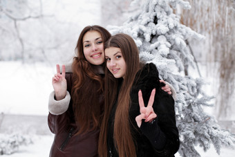 冬天雪景中两个女孩比耶