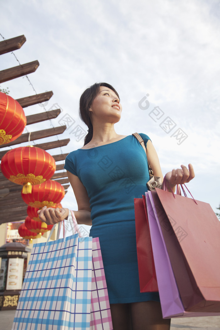 年轻的女人户外城市购物购物袋灯笼喜庆摄影