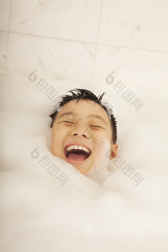 小男孩泡澡浴缸泡泡洗澡开心的微笑摄影图片