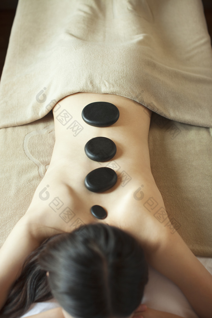 理疗按摩躺着舒服的女人石头养生摄影图