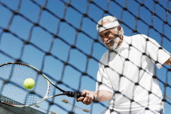 蓝色调打着网球的老人摄影图