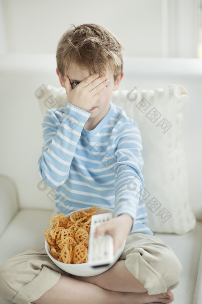 吃零食看電視的小男孩