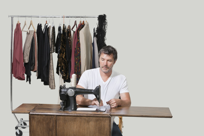 缝纫机做衣服的男人摄影图