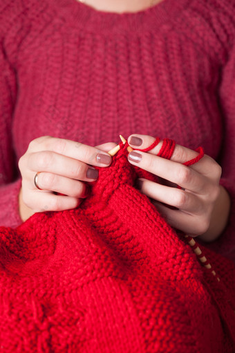 女士正在织红色毛衣