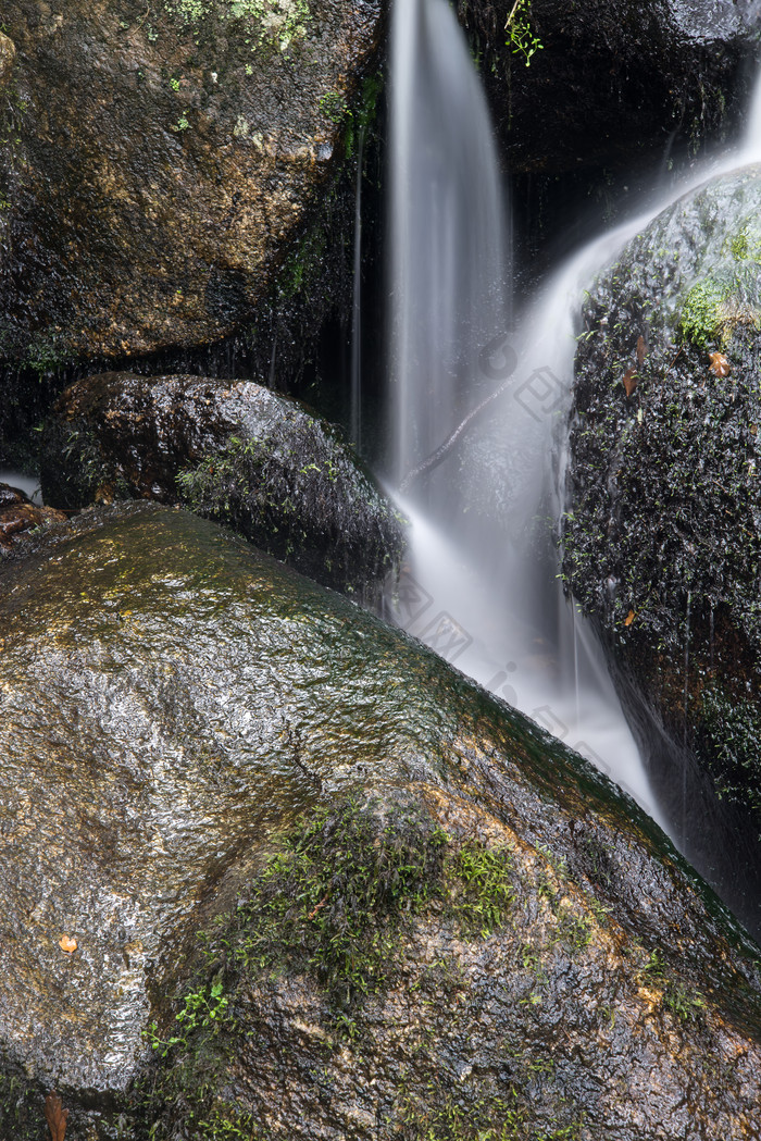 岩石中瀑布流水摄影图