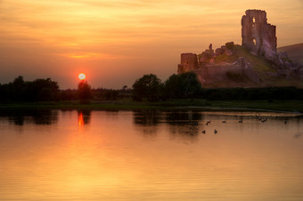 暗色调黄昏中的水边城堡摄影图