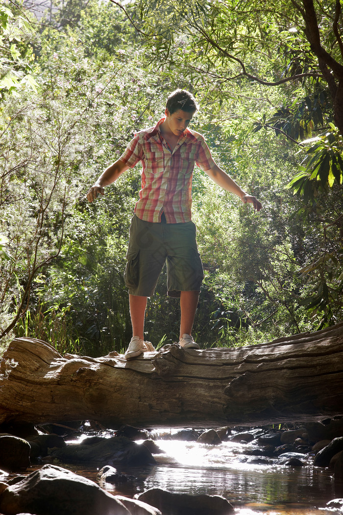 站在木头上过河的男生