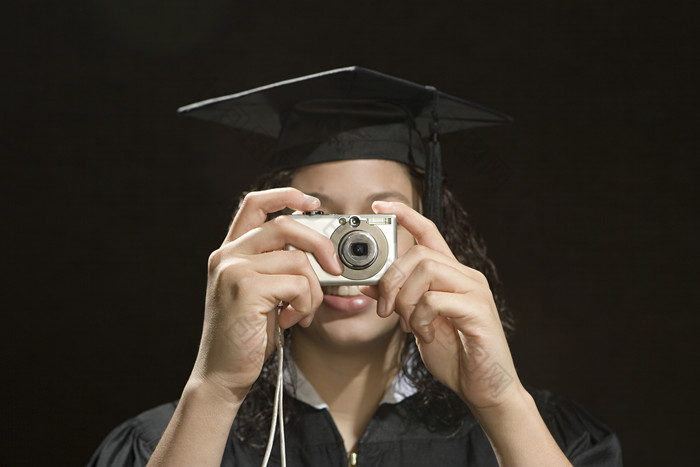 暗色调在拍照的女毕业生摄影图