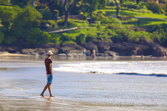 男人走在海滩上摄影图