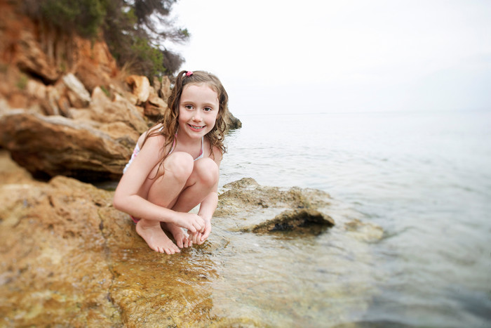 蹲在海边的裸体小女孩