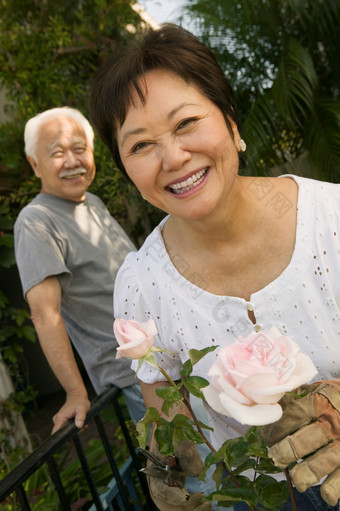 深色调拿<strong>盆景</strong>的老夫妻摄影图