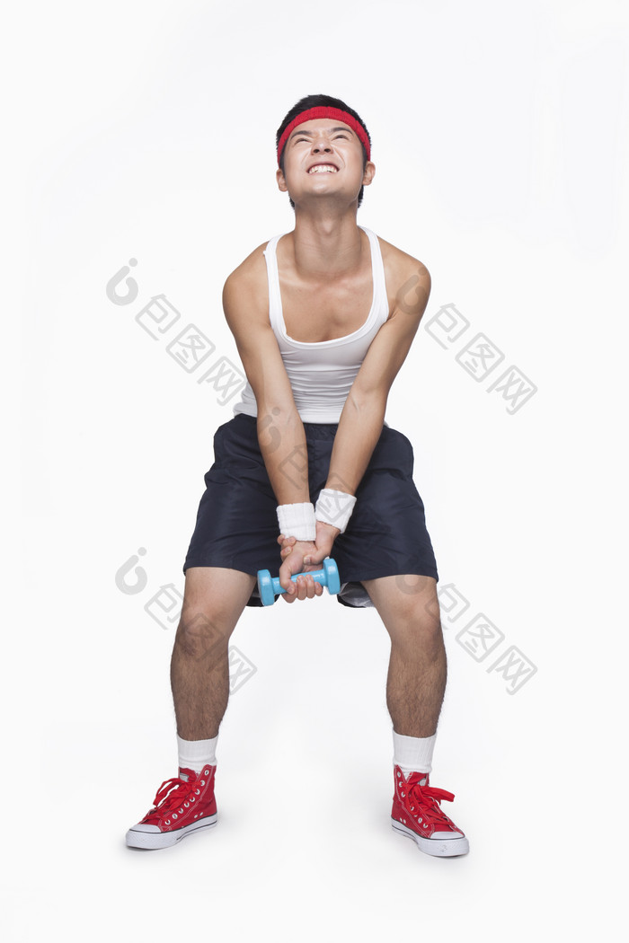 年轻的男子锻炼举哑铃吃力的健康摄影