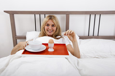 灰色调在床上吃饭的一个女人摄影图