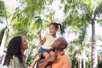 黑人父母和女儿树下玩耍