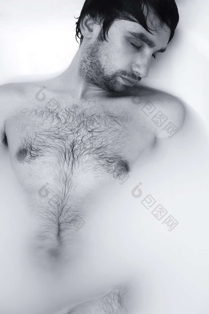赤裸的男人躺在浴缸泡沫里