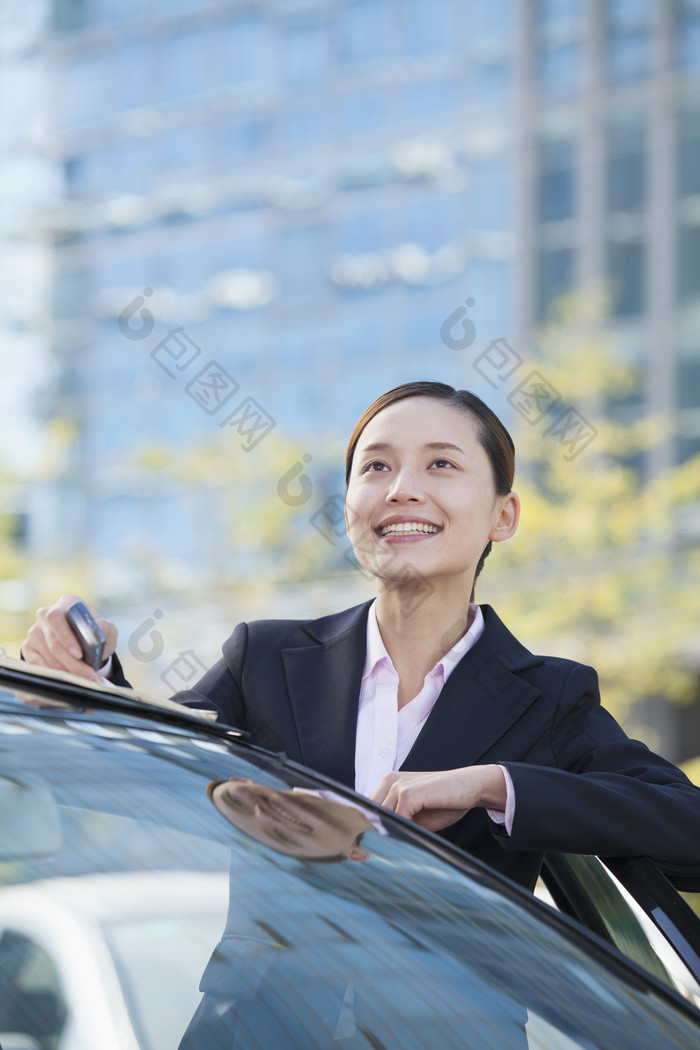 车辆旁仰头微笑的商务女士