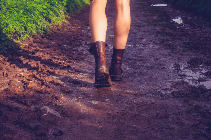 暗色调泥路中行走的人摄影图