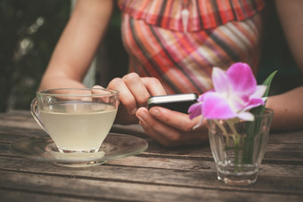 喝茶玩手机的女人摄影图