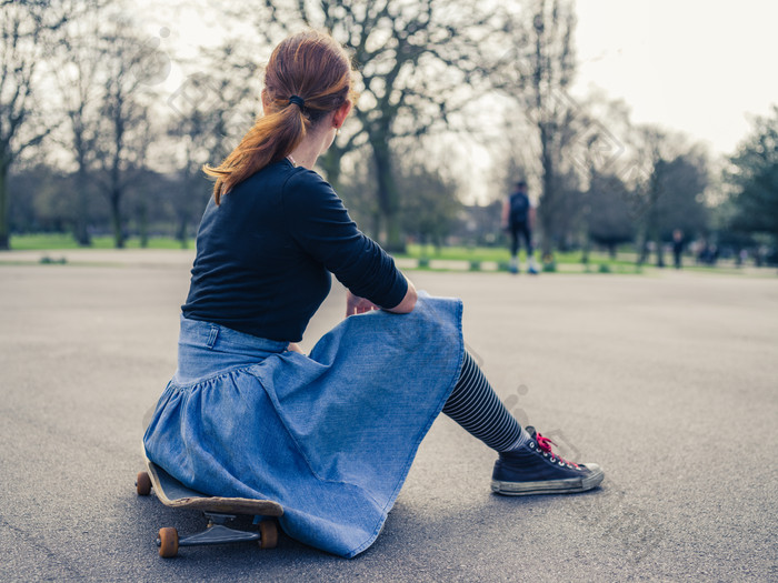 公园玩滑板休息的女孩