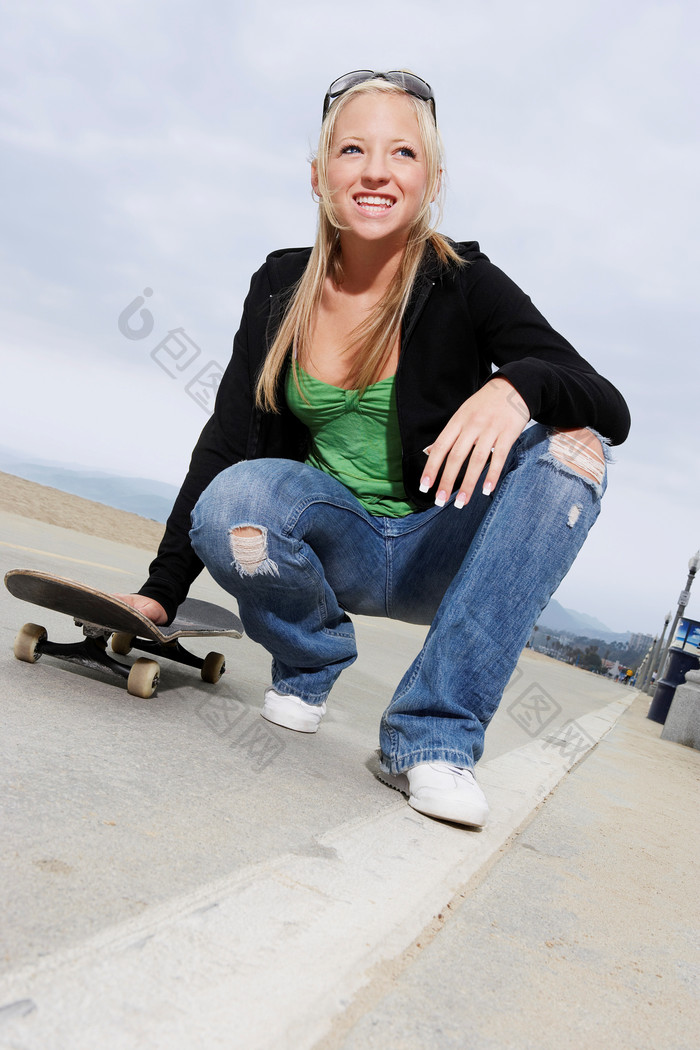 深色调玩滑板的女孩摄影图