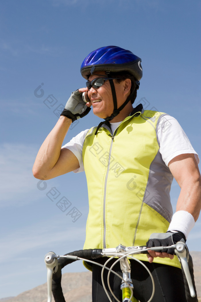 蓝色调打电话的骑车人摄影图