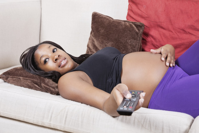 黑人孕妇躺在沙发上调台