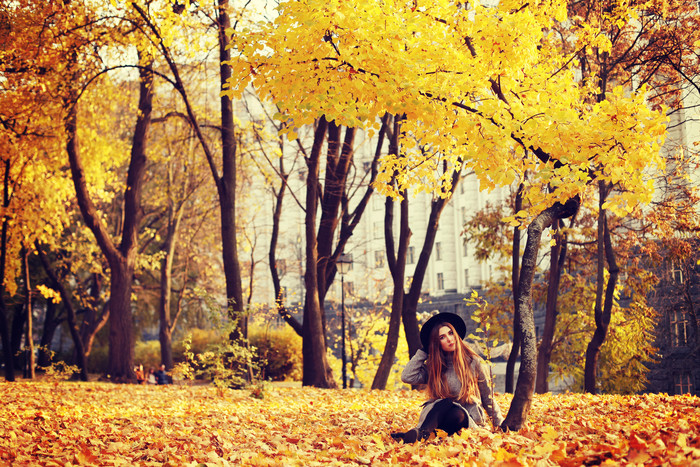 坐在秋季落叶上的女人