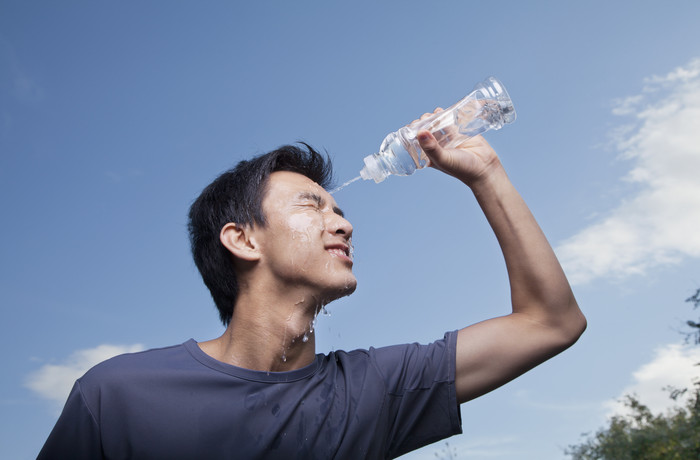 往脸上泼水的男人摄影图