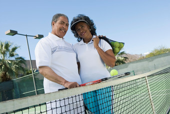 蓝色调网球场地中的夫妻摄影图