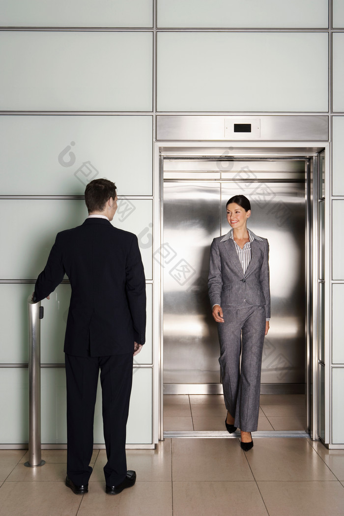 深色调乘电梯的人摄影图