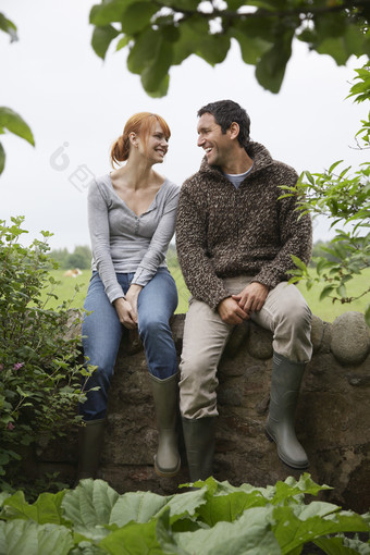 深色调野外坐着的情侣摄影图