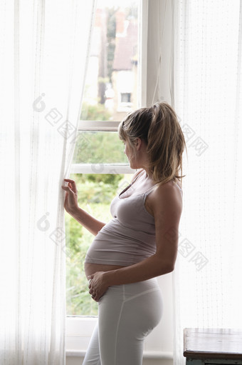 站在窗户边上的美女孕妇
