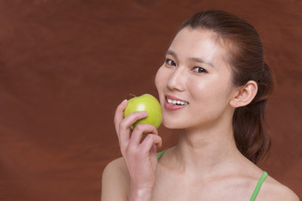 吃青苹果的女人摄影图