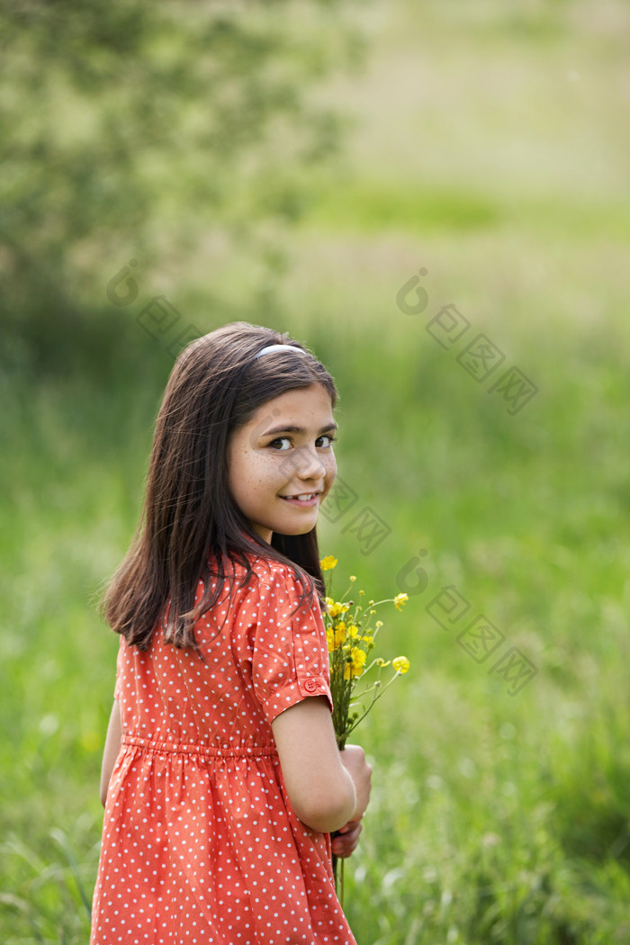 绿色调在草地中的小女孩摄影图