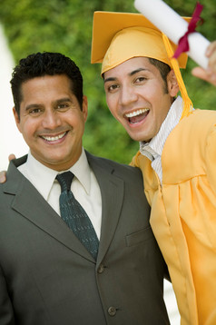 拿着毕业证书的男孩和父亲