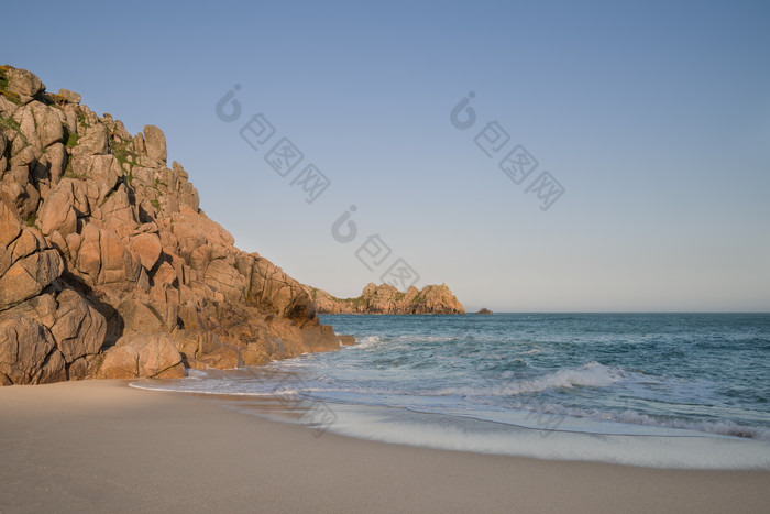 海滩边的石头山摄影图