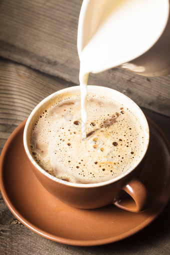 牛奶倒入咖啡中摄影图