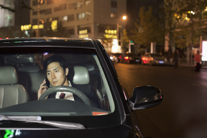 夜晚汽车车内接电话男人业务开车城市摄影图