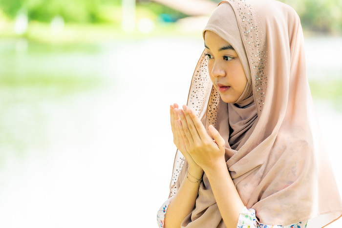 阳光下祈祷的穆斯林女孩