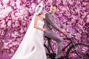 花墙边骑自行车的夫妻图片