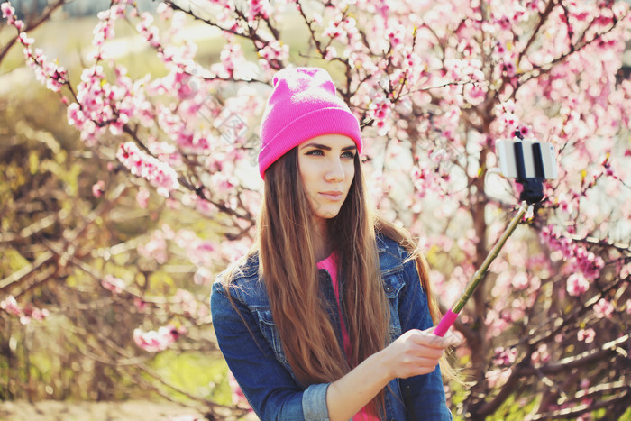 拿自拍杆拍照的女孩