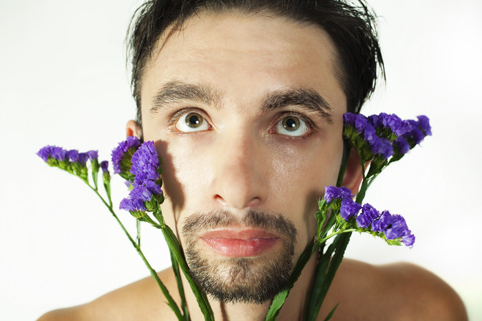 简约拿紫花的男人摄影图